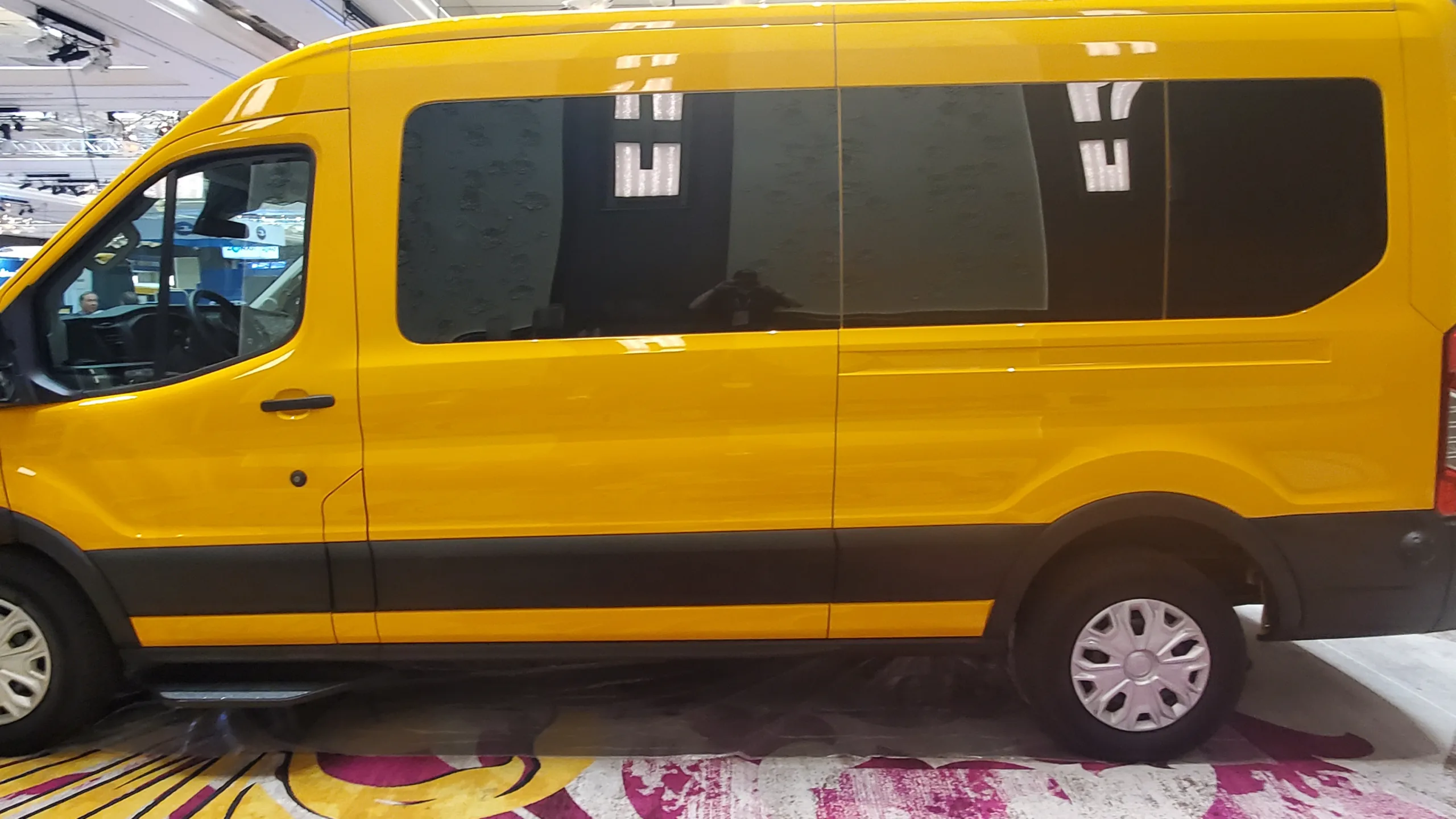 Small school buses and shuttles from RO Bus picking up students at a school campus